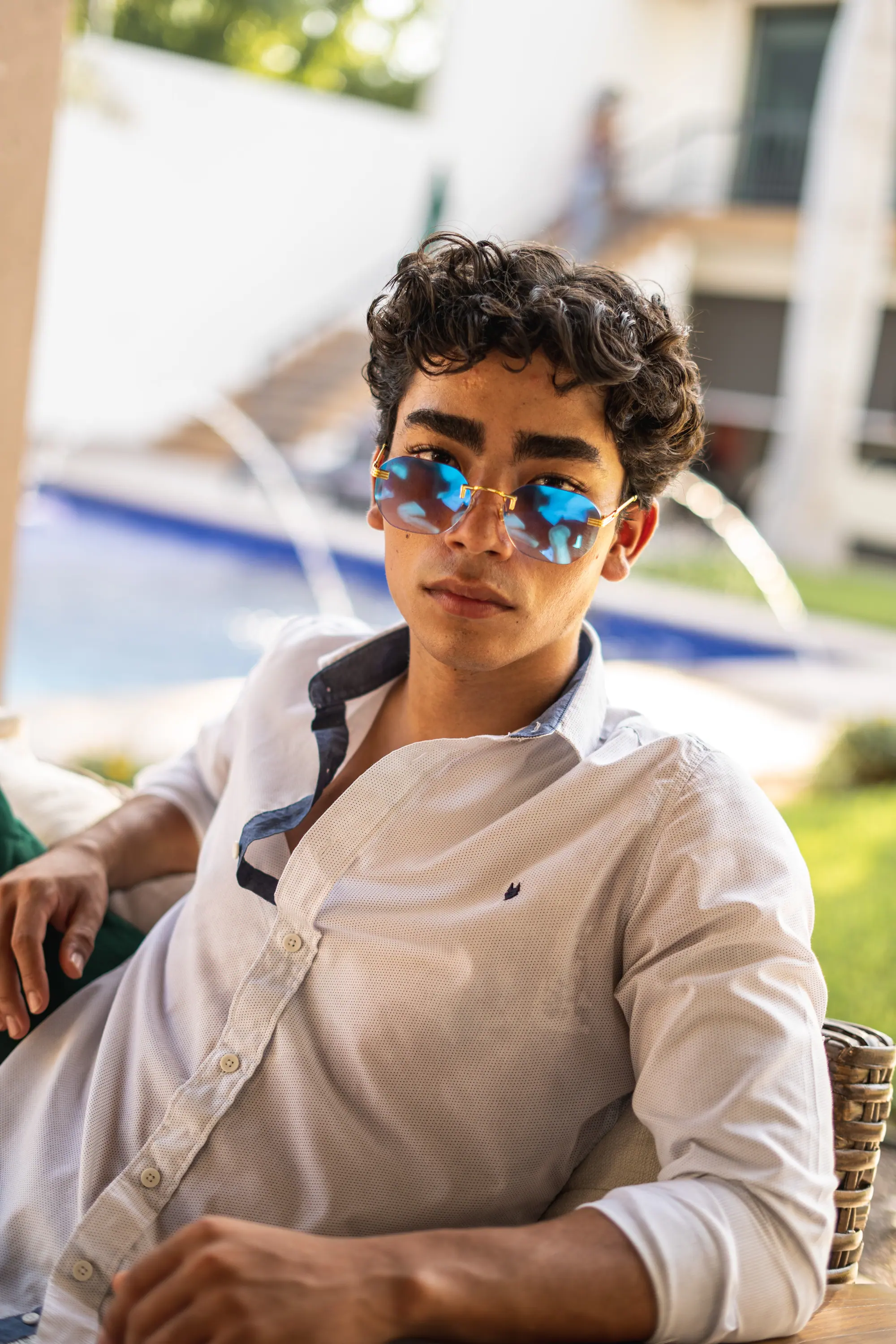 Lentes espejeados azules y camisa blanca