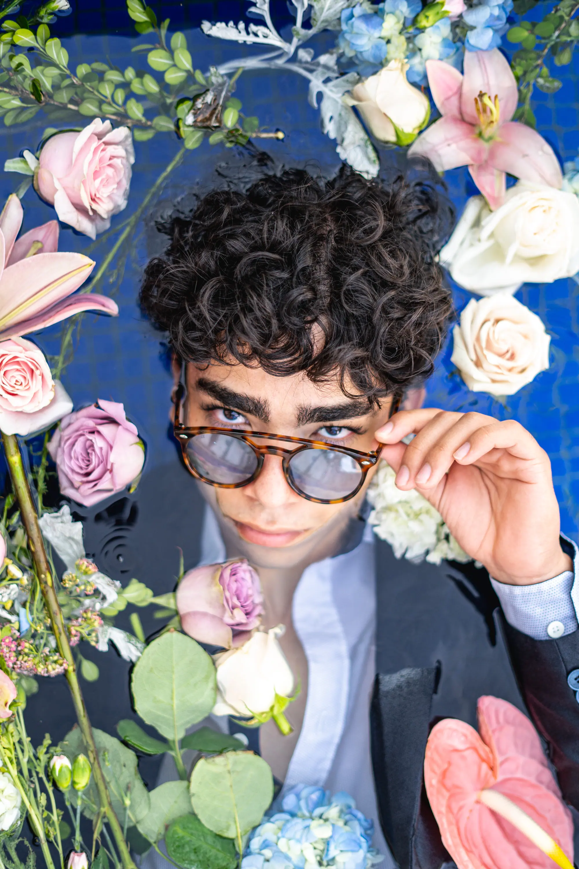 Retrato entre lirios y rosas con lentes espejeados