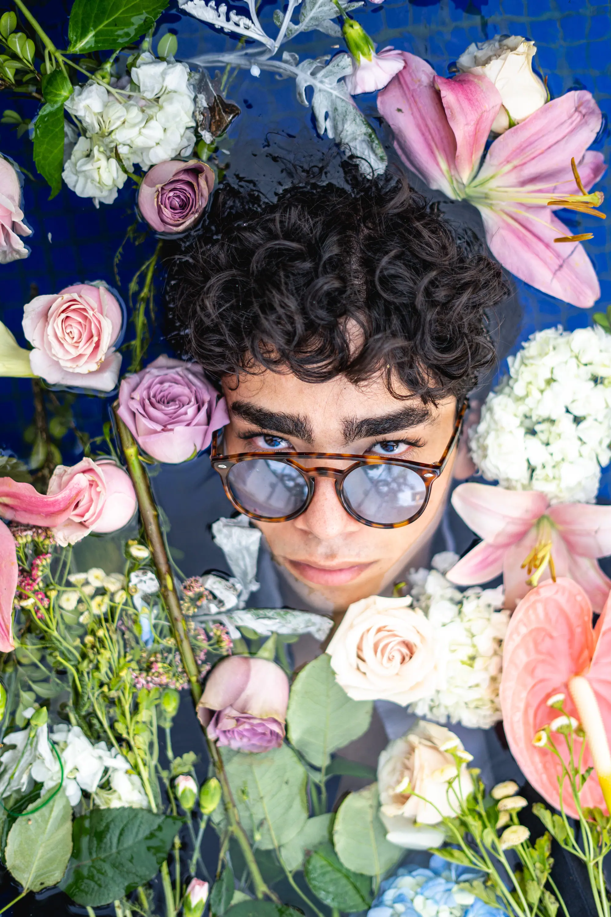 Lentes espejeados entre rosas y anturios