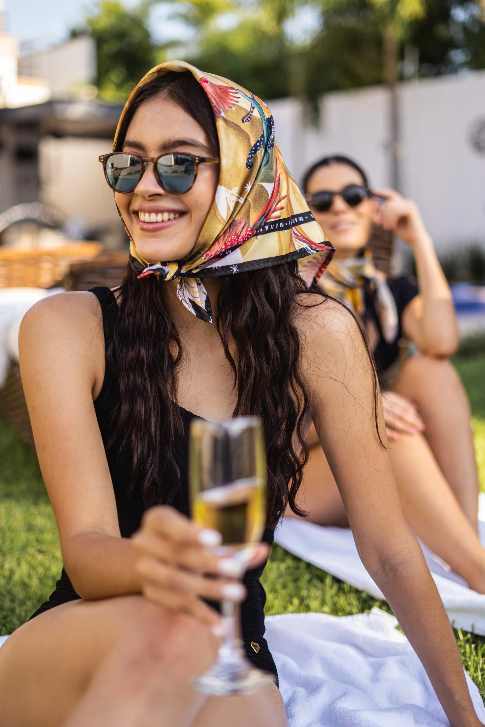 Sonrisa con copa en alto y lentes de sol