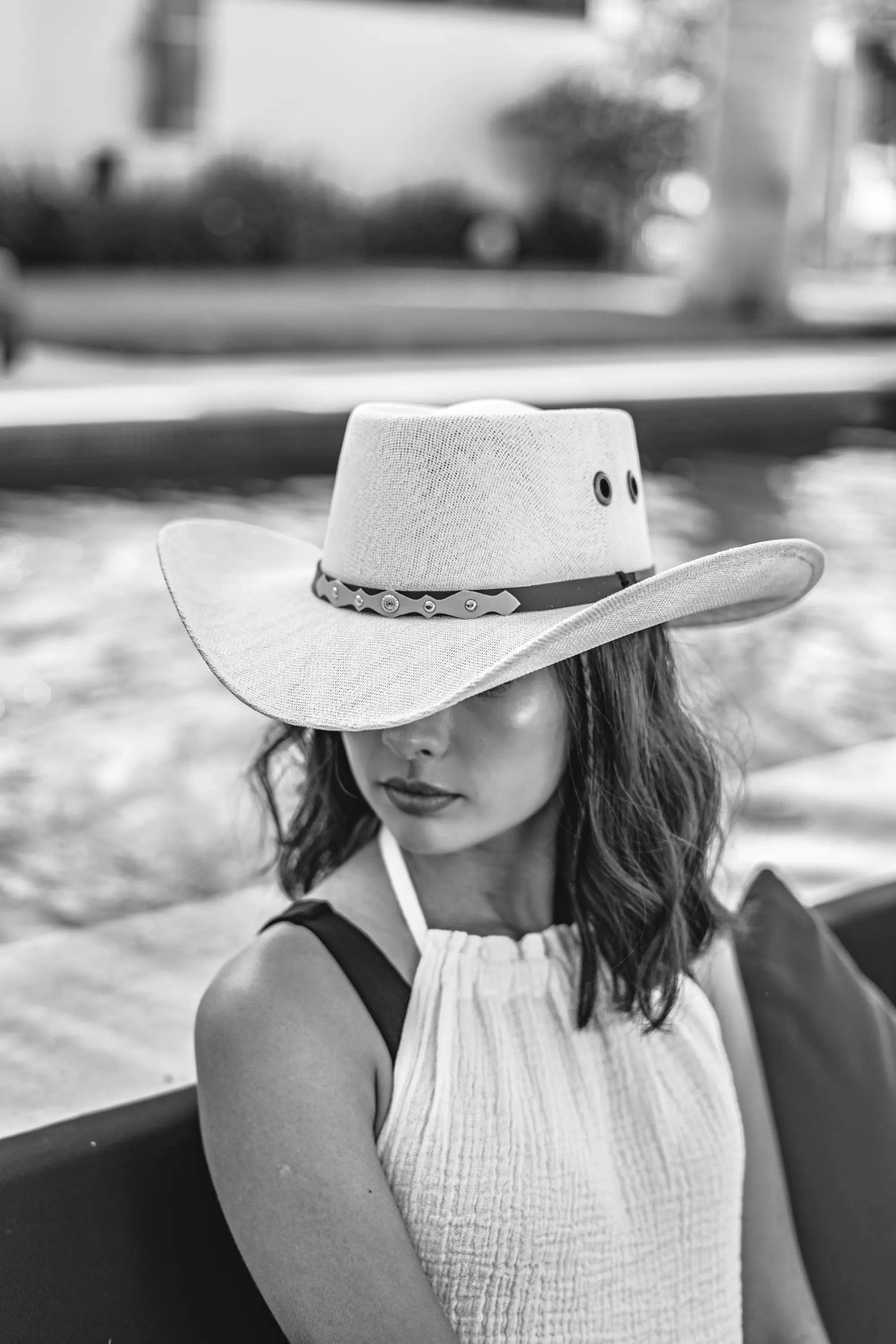 Sombrero de ala ancha en blanco y negro junto a la alberca