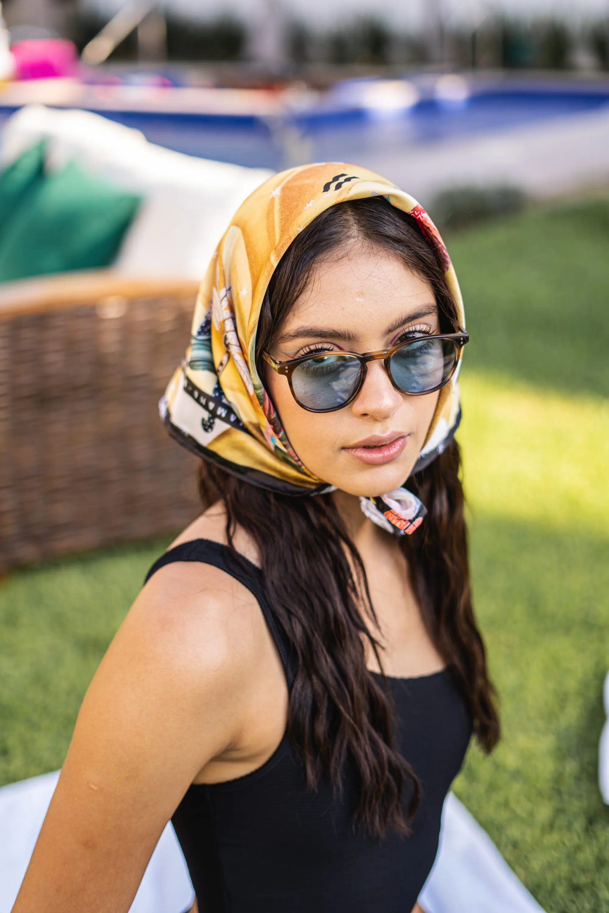 Pañuelo estampado y lentes de carey junto a la alberca